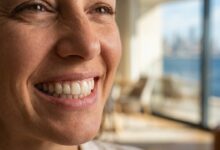 A photorealistic close-up of a person's beautiful, healthy white teeth, showcasing a perfect smile as a result of successful cosmetic dentistry, set against a clean, modern, blurred background.