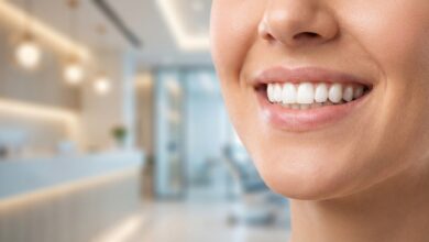 A detailed close-up photograph of a person's healthy, bright white teeth and radiant smile. The background is a softly blurred, modern dental office, emphasizing a professional and clean environment.