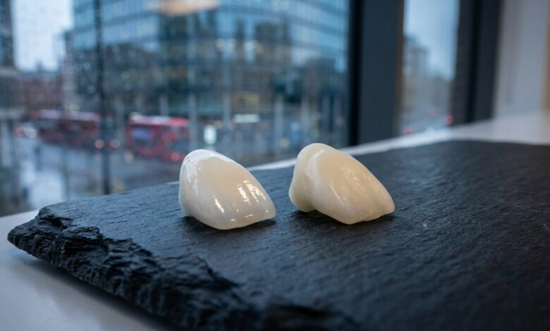 A photorealistic close-up of a high-quality porcelain veneer and a composite veneer on a clean surface, with a blurred background of a modern UK city, symbolizing the cost of cosmetic dentistry.