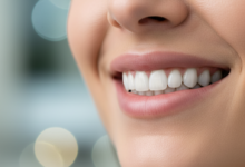Close-up of a person's lower face with a confident, natural, and healthy smile, featuring clean, strong teeth. The background is softly blurred, suggesting a professional and calming environment, conveying successful dental implant recovery.
