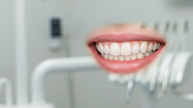 A close-up, photorealistic image of a perfect, radiant smile with healthy, bright, and perfectly aligned teeth. The background is a softly blurred, clean, and modern dental clinic interior.