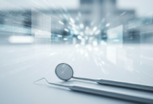 Close-up of sterile, gleaming dental tools (mirror and probe) resting on a light blue, clean surface. The background is softly blurred with abstract light patterns and indistinct shapes, subtly hinting at financial data and a modern UK building, representing healthcare costs and accessibility.
